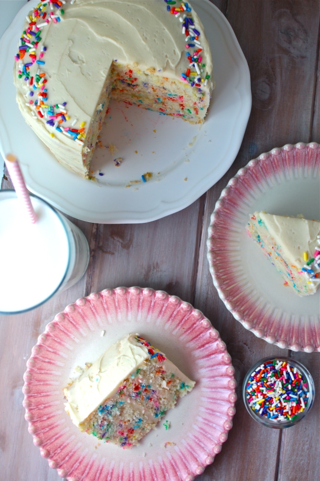 This Funfetti Cake is swathed in a delicious vanilla buttercream frosting and loaded with sprinkles for the perfect celebratory treat! | The Millennial Cook #cake #funfetticake #birthdaycake #sprinkles