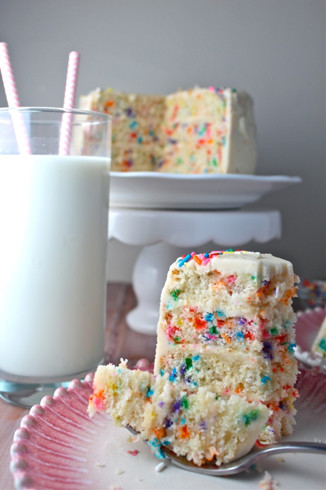 This Funfetti Cake is swathed in a delicious vanilla buttercream frosting and loaded with sprinkles for the perfect celebratory treat! | The Millennial Cook #cake #funfetticake #birthdaycake #sprinkles