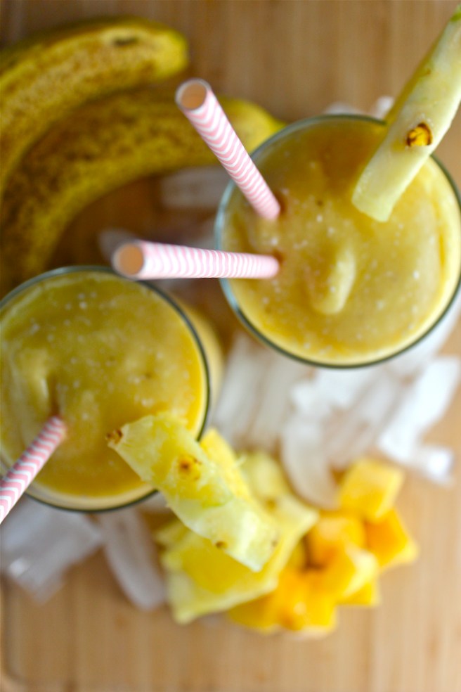 This Tropical Fruit Smoothie - with lots of pineapple, mango, and rich coconut milk - is fruity, frosty, tart, and creamy! | The Millennial Cook #winterrecipe #smoothie #orange #banana #mango #pineapple #coconut