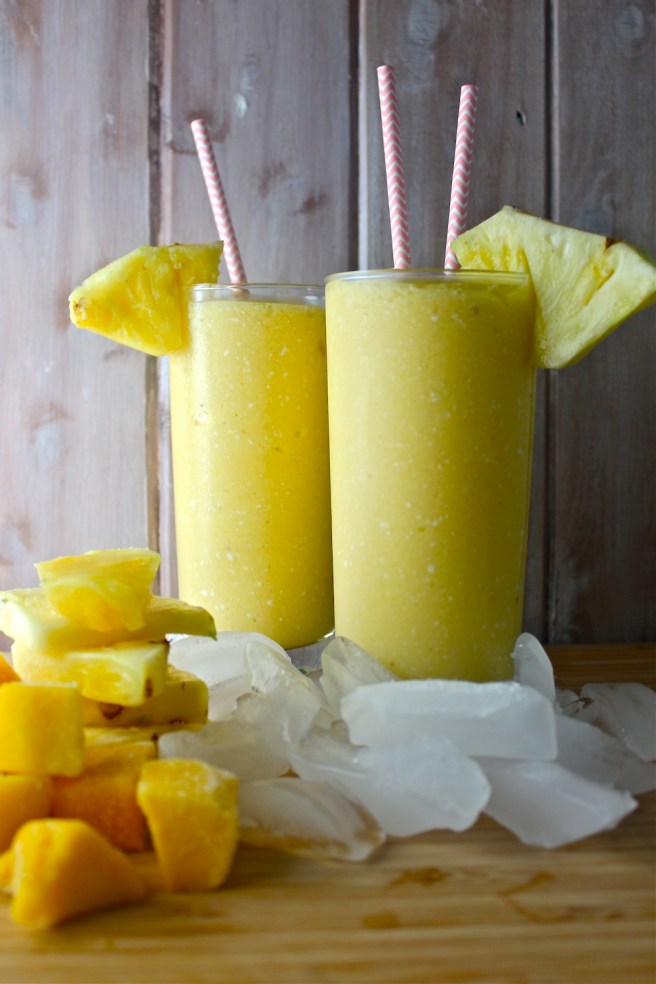 This Tropical Fruit Smoothie - with lots of pineapple, mango, and rich coconut milk - is fruity, frosty, tart, and creamy! | The Millennial Cook #winterrecipe #smoothie #orange #banana #mango #pineapple #coconut