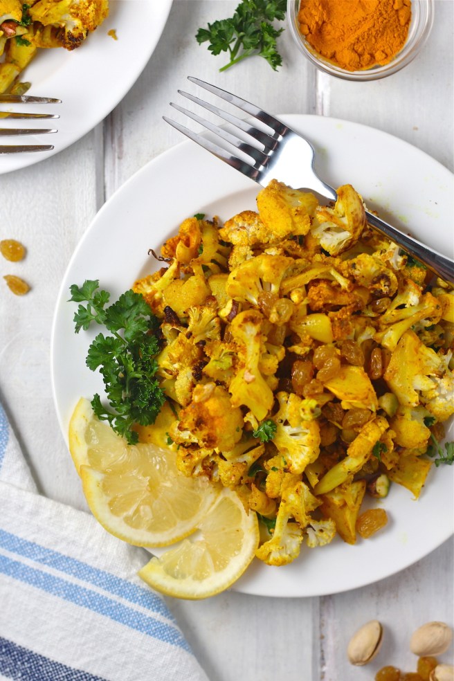 This Turmeric Roasted Cauliflower Salad is a light and tasty dish filled with roasted cauliflower, turmeric, cumin, golden raisins, and bright lemon juice| The Millennial Cook #salad #cauliflower #turmeric
